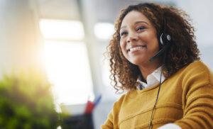 Young african woman, call center agent or listen on voip headset with mockup space, lens flare or contact. Girl, customer service or tech support crm with smile, headphones or microphone at help desk.